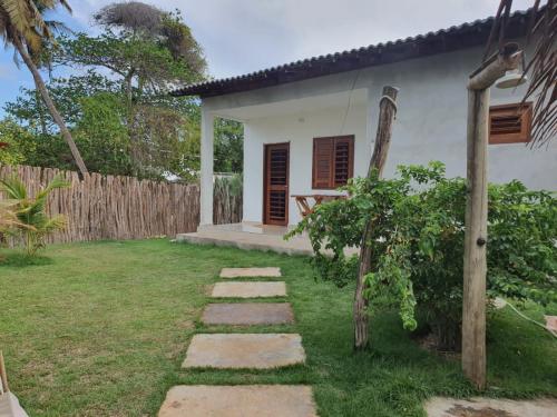 ein Haus mit einem Garten und einem Weg in der Unterkunft Chalé Calú in Barra Grande
