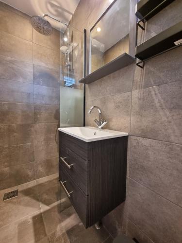 a bathroom with a sink and a shower at De Schelp 73 the perfect place! in Zandvoort