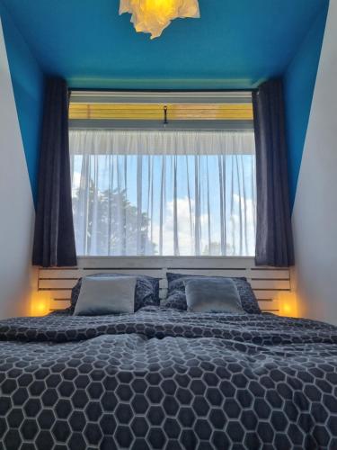 a bedroom with a large window and a large bed at De Schelp 73 the perfect place! in Zandvoort