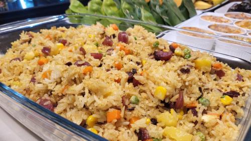 a dish of rice with vegetables and other foods at DUM Hotel - Si Phum in Chiang Mai