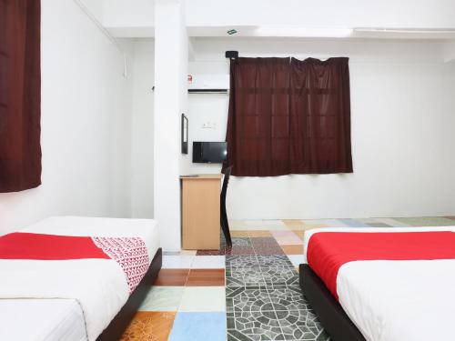 a room with two beds and a window at KB Rest Inn-Family Triple in Kota Bharu