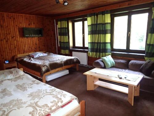 Habitación de hotel con 2 camas y sofá en Chata Krpáčovo en Horná Lehota