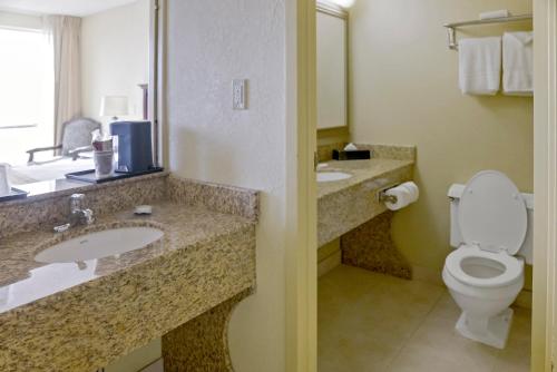 a bathroom with a toilet and two sinks in a hotel at Economy Hotel Plus Wichita in Wichita