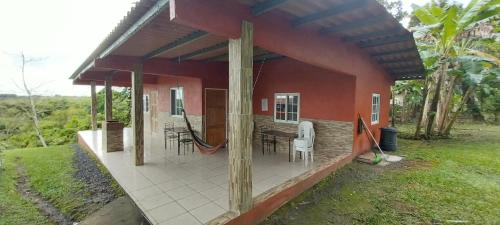 a house with a porch with a table and chairs at Hotel Cabañas Casita La Ermita in San Carlos