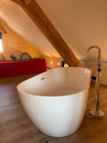 baño con bañera blanca en el suelo de madera en Blackforest Homestay en Herrischried