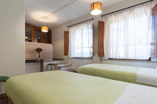 Locanda Sighimi في لاينوساي: غرفة فندقية بسريرين ومطبخ