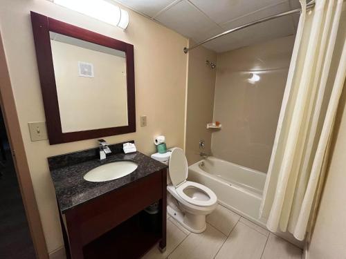 a bathroom with a sink and a toilet and a mirror at Circle Motor Lodge in South Amboy