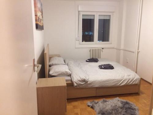 a small bedroom with a bed and a window at Newly equipped Arena apartment in Belgrade