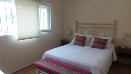 a bedroom with a white bed with two pillows at Buenos Aires Apart in Salta