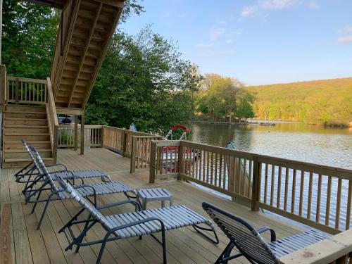a deck with chairs and a view of a lake at Large family house on the lake in Hewitt