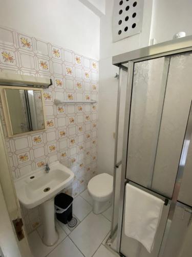 a bathroom with a toilet and a sink and a shower at Grande Hotel Torres in Torres