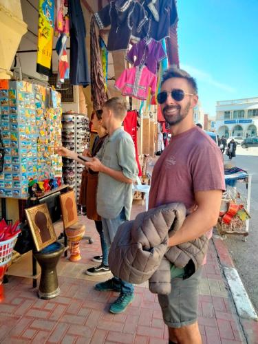 a man standing in front of a store holding a ball at Dar Hkaïem in Sousse