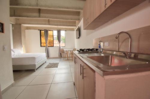 una cocina con fregadero y una cama en una habitación en MANGATA LIVING, en Medellín