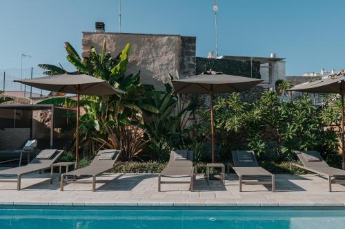 a group of chairs and umbrellas next to a pool at PALAZZO FRANGIPANE in Salve