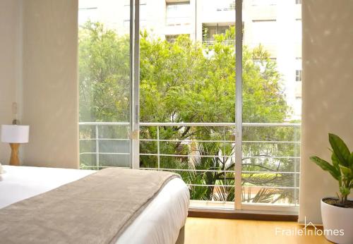 a bedroom with a bed and a large window at FH - Stylish loft in Chico Norte - Bogota in Bogotá