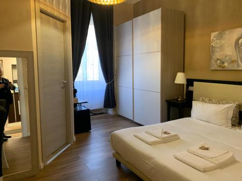 a bedroom with a bed with two towels on it at Domus La Foce Hotel self check in in Genova