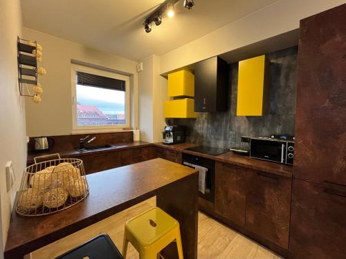 a kitchen with yellow cabinets and a counter top at Yellow - Bastion Wałowa EV center free parking in garage in Gdańsk
