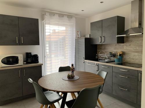 une cuisine avec une table et des chaises dans une cuisine dans l'établissement Les balcons de la haie griselle, à Gérardmer