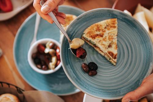a person eating a slice of pizza on a blue plate at PALAZZO FRANGIPANE in Salve