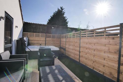 a backyard with a wooden fence and a bath tub at Hoxne Cottages - Rose Cottage with private hot tub in York
