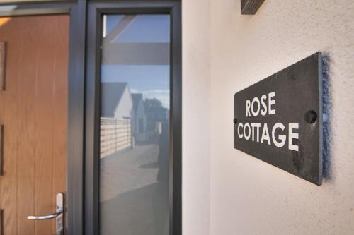 eine Tür mit einem Aroma-Konferenzschild an der Seite eines Gebäudes in der Unterkunft Hoxne Cottages - Rose Cottage with private hot tub in York