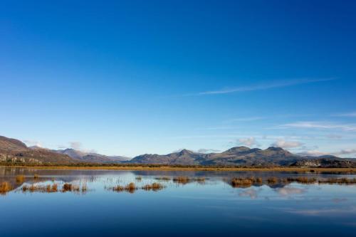 una gran masa de agua con montañas en el fondo en Newly-renovated, mid-terrace cottage in Porthmadog en Porthmadog