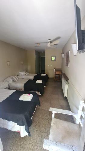 a room with three beds and a ceiling fan at Hotel Agustin Garcia in Tigre