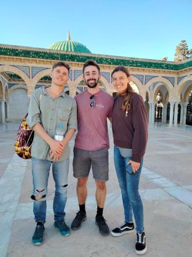 three people standing in front of a building at Dar Hkaïem in Sousse