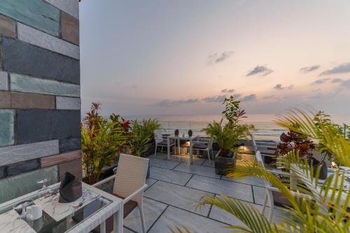 a patio with tables and chairs and the ocean at Hotel Ocean Grand at Hulhumale in Hulhumale