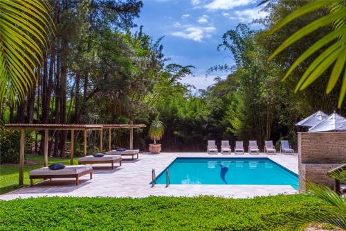a swimming pool with chaises and chairs next to at Itu Garden - SPA e Resort Saudavel in Itu