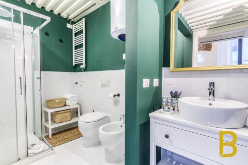 La salle de bains est pourvue d'un lavabo, de toilettes et d'un miroir. dans l'établissement BePlace Apartments in Gae Aulenti, à Milan