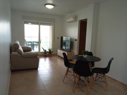 ein Wohnzimmer mit einem Tisch, Stühlen und einem Sofa in der Unterkunft OceanView Apartment in La Manga del Mar Menor