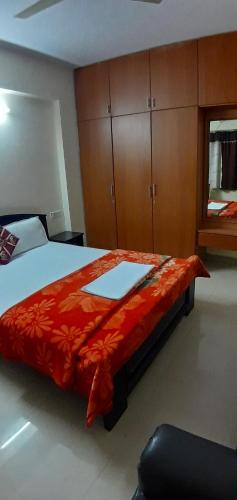 a bedroom with a large bed with a red blanket at Apartment Home Stay in Bangalore