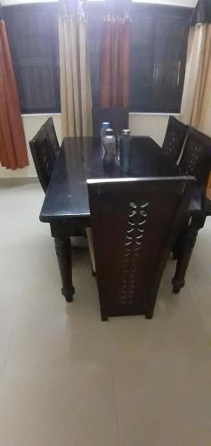 une table noire avec deux chaises et un noir dans l'établissement Apartment Home Stay, à Bangalore