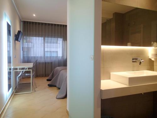 a bathroom with a sink and a bed at Hotel Vila da Guarda in A Guarda