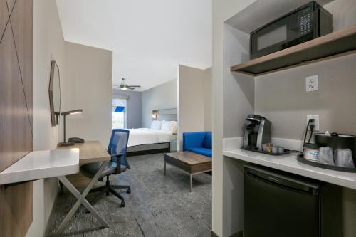 a hotel room with a bed and a desk and a room at Holiday Inn Express & Suites North Dallas at Preston by IHG in Dallas