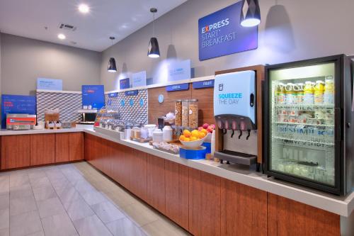 a grocery store with a cashier and a food counter at Holiday Inn Express & Suites North Dallas at Preston by IHG in Dallas