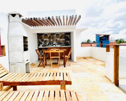 a patio with a wooden table and chairs at Villa Mar Residence in Jericoacoara