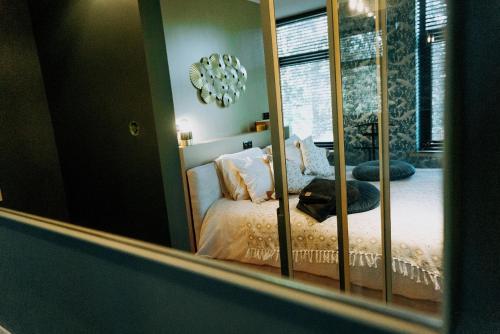 une chambre avec un lit dans un miroir dans l'établissement Fiertelmeers Boutique B&B, à Ronse