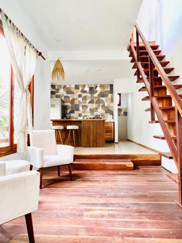 a living room with a staircase and a kitchen at Villa Mar Residence in Jericoacoara