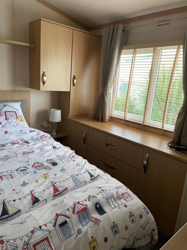 1 dormitorio con cama con edredón en ParkDean cherry tree holiday park, en Great Yarmouth