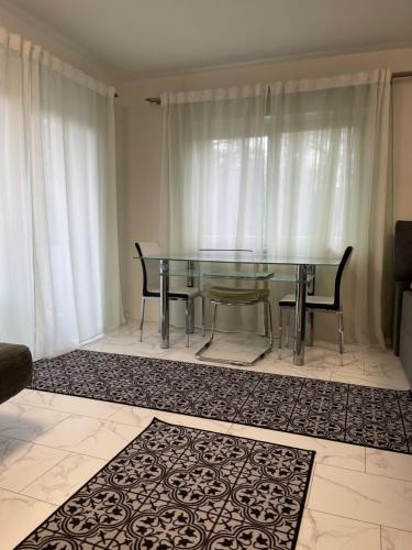 a glass table and two chairs in a living room at Apartment Rot-Kreuz in Bad Säckingen