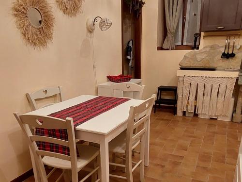 a kitchen with a white table and chairs and a stove at Nel vicolo dei Baci - Casa vacanze al Bacio in Spello