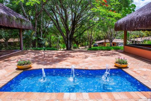 a swimming pool with two fountains in a yard at Itu Garden - SPA e Resort Saudavel in Itu