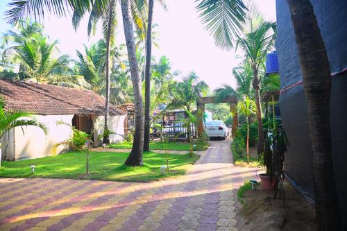 a street with palm trees next to a building at Madhu Huts Agonda in Agonda