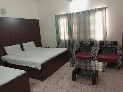 a room with two beds and a couch and a table at Karachi Guest House & Couple Hotel in Karachi