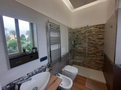 a bathroom with a sink and a toilet and a window at Natural Mente in Pompei