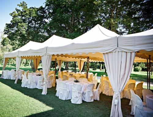 a group of tables and chairs under a white tent at Château de Peufeilhoux in Vallon-en-Sully