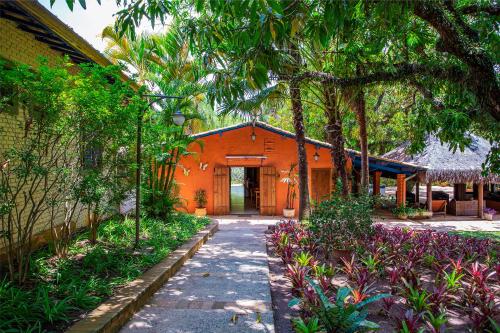 an orange building with a walkway in a garden at Itu Garden - SPA e Resort Saudavel in Itu