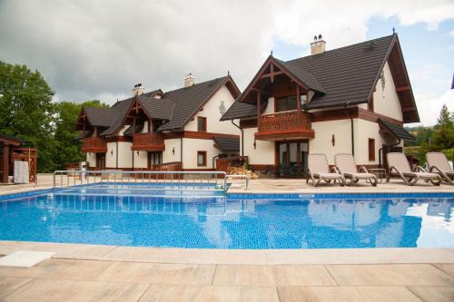 a house with a swimming pool in front of it at PARZENICA in Jaworki